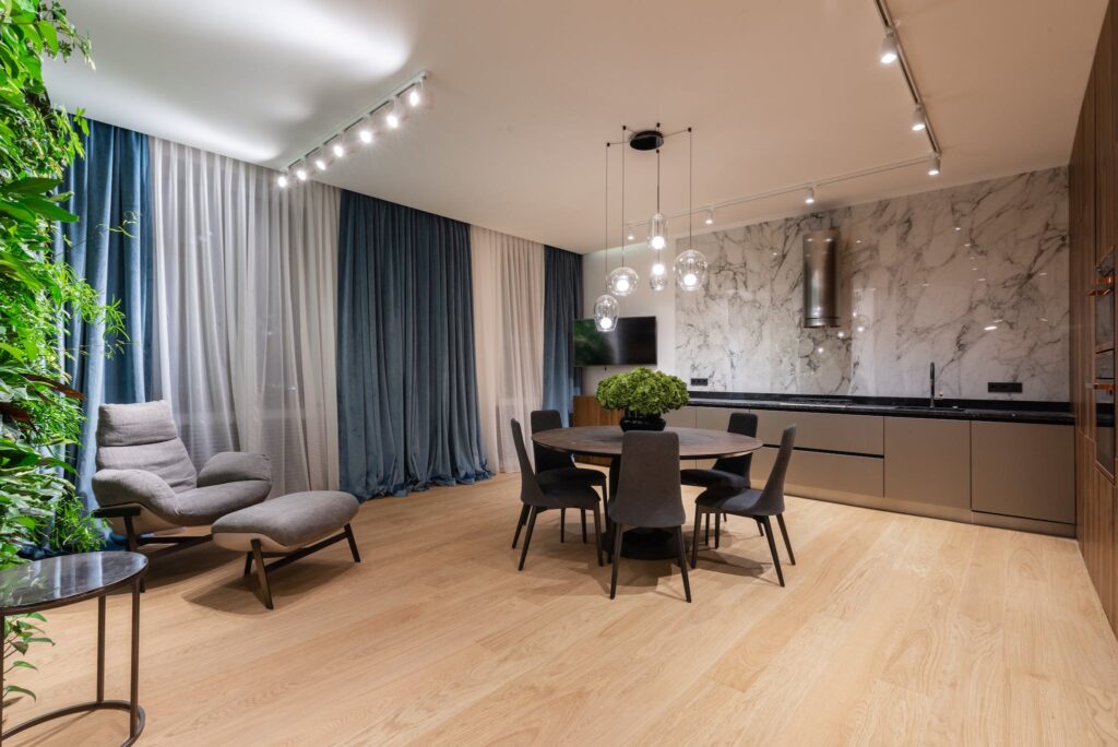 Studio interior with table with chairs near kitchen and armchair